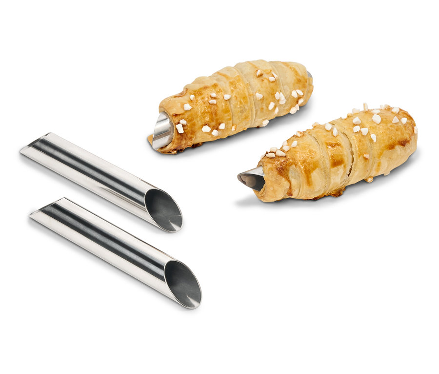 Két krémmel töltött tésztarúd fekszik két fémforma mellett.