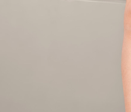 Kislány ül és mutat az ujjával, rajta 5 kisgyerek hosszú ujjú body, fehér.