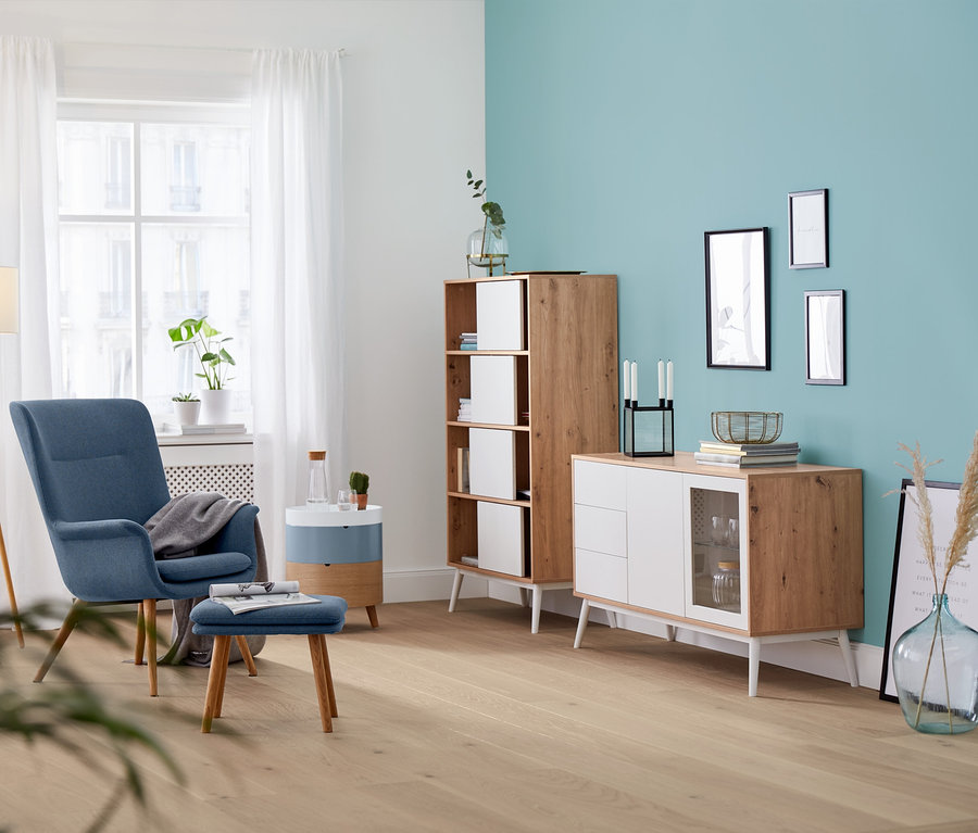 Nappali kék fotellel, puffal és fa állólámpával.