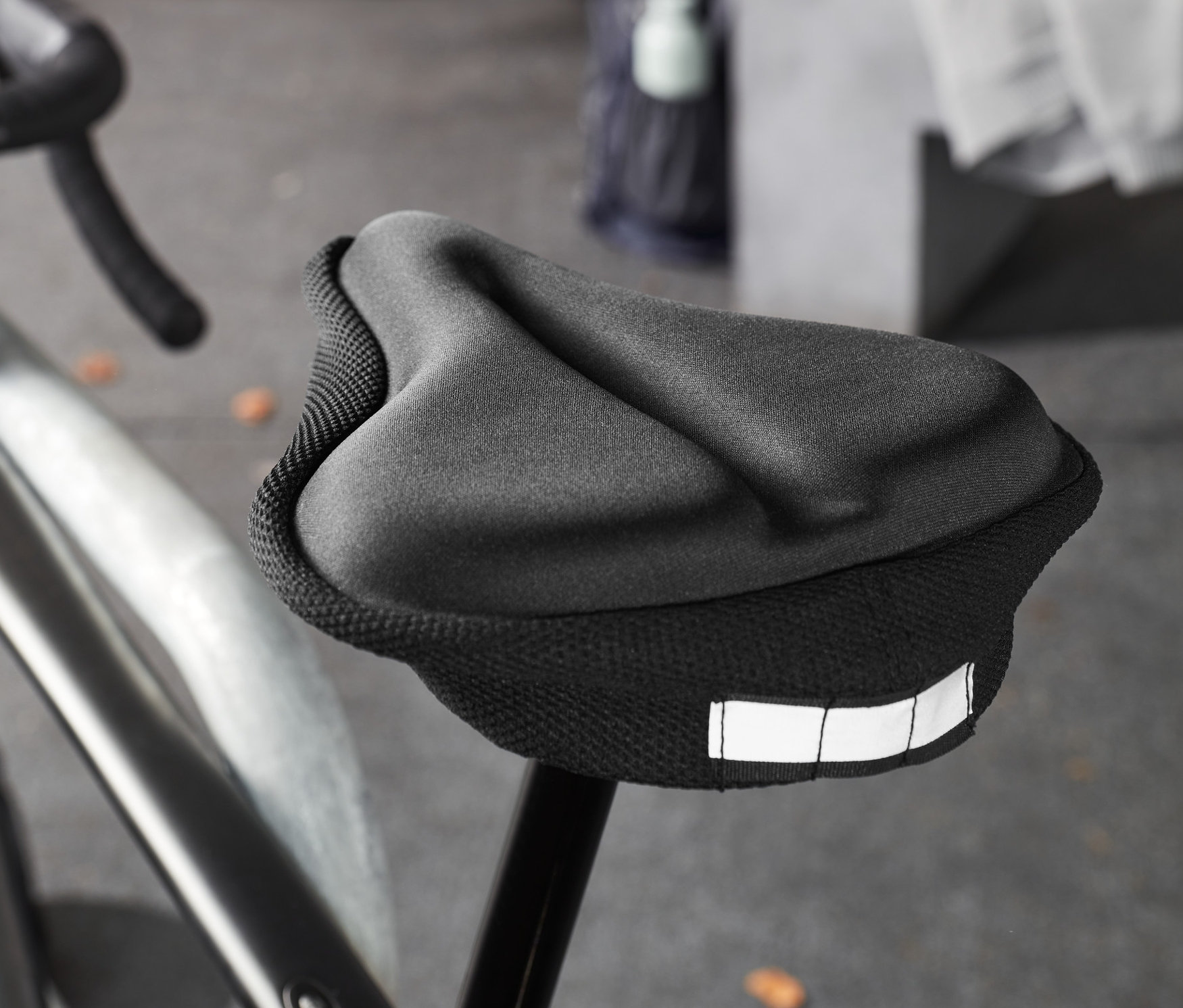 Egy fekete kerékpár közeli képe fekete, memóriahabos nyereghuzattal.