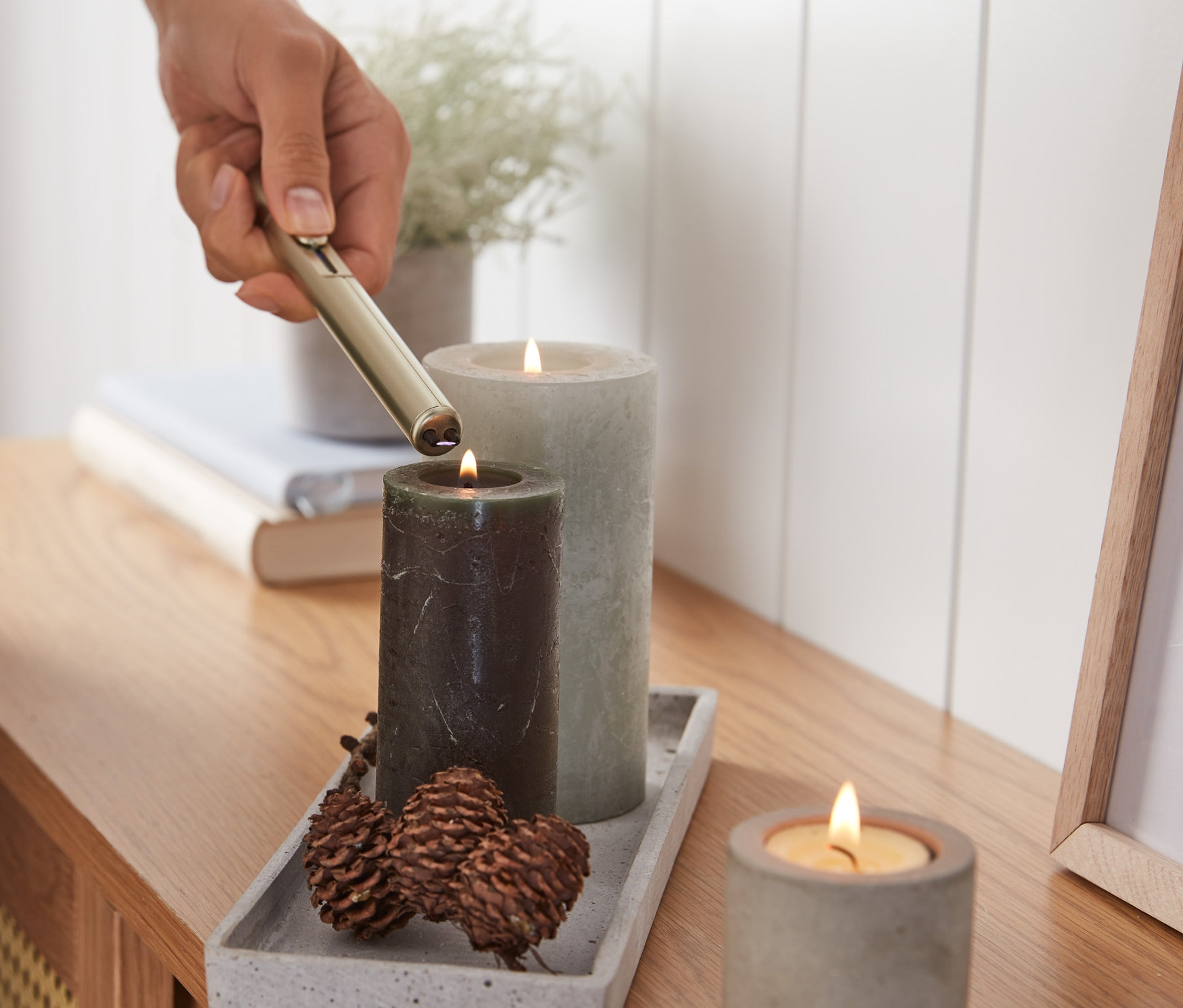 Egy személy gyertyát gyújt elektromos fényív-öngyújtóval.