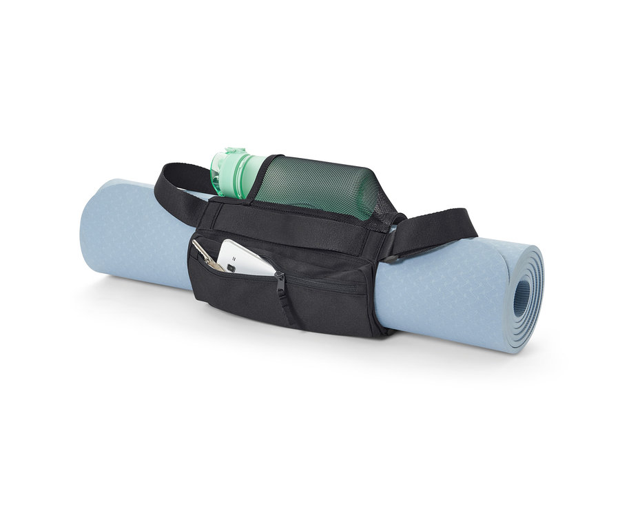 A kék jógamatrac egy fekete hordozópánt fitneszmatrachoz van rögzítve. A pánt zsebében mobiltelefon és kulcsok, a hálós zsebben pedig egy zöld vizes palack található.
