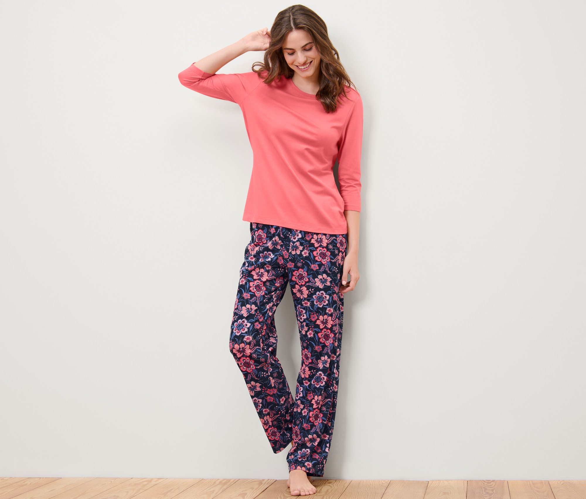 Nő virágmintás pizsamában pózol.