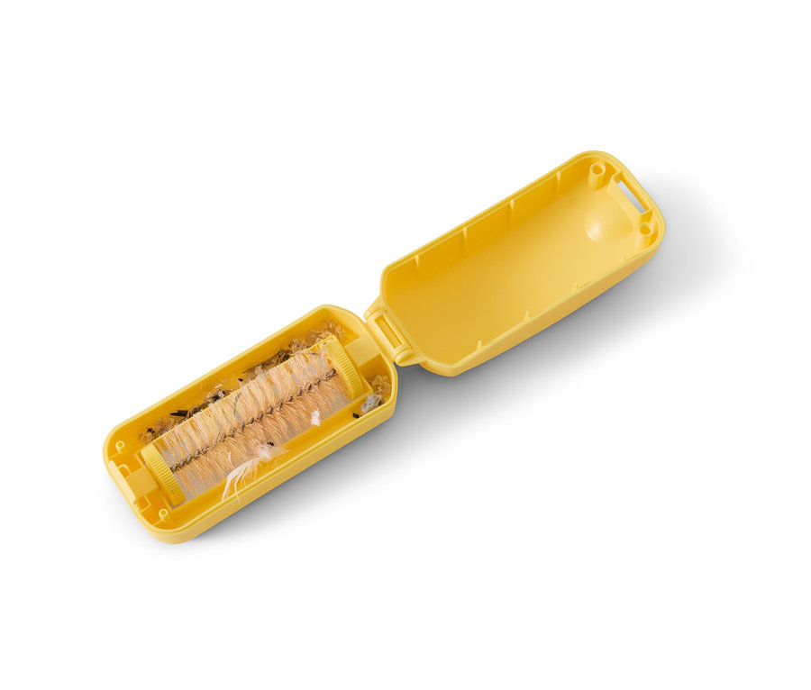 Nyitott sárga morzsaseprű összegyűjtött szennyeződésekkel.