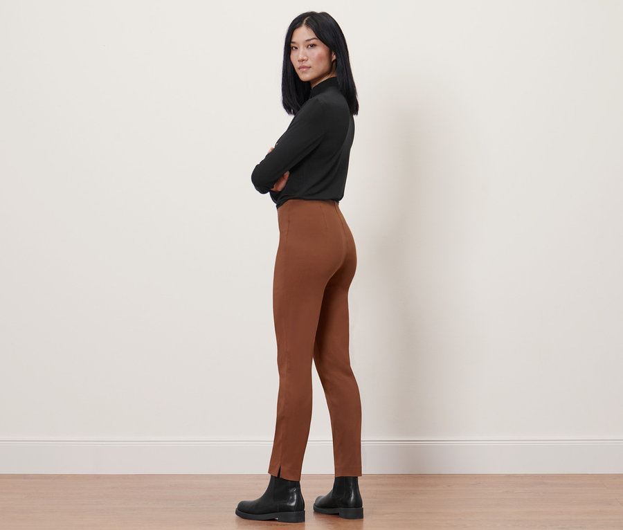 Nő pózol konyak színű sztreccsnadrágban.