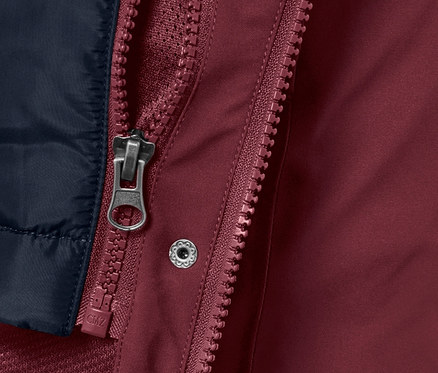 Egy piros, 3 az 1-ben outdoor kabát részlete mellénnyel, a cipzár és a gomb látható.