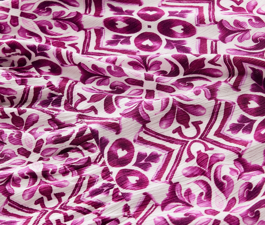 Egy fukszia mintás női szövött ruha részlete.