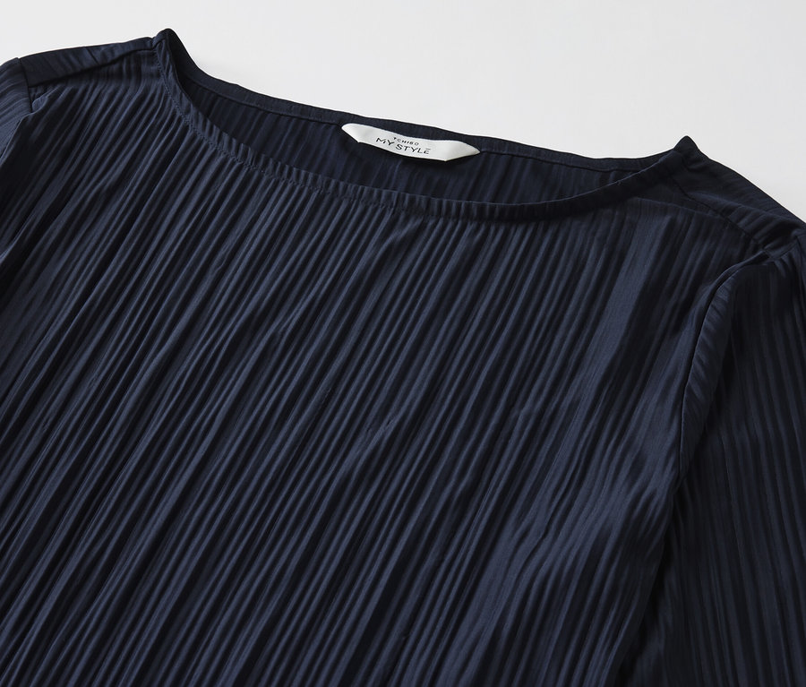 Egy sötétkék női pliszé pólóblúz részlete.