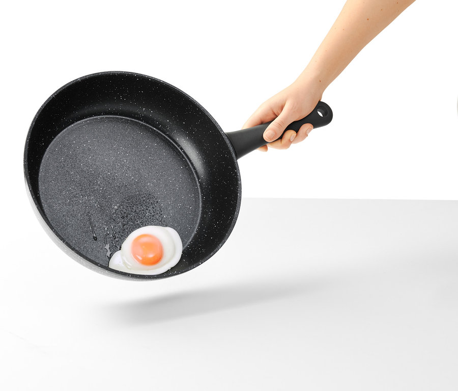 Egy kézben egy 28 cm-es, kőhatású profi serpenyőben tükörtojás van.