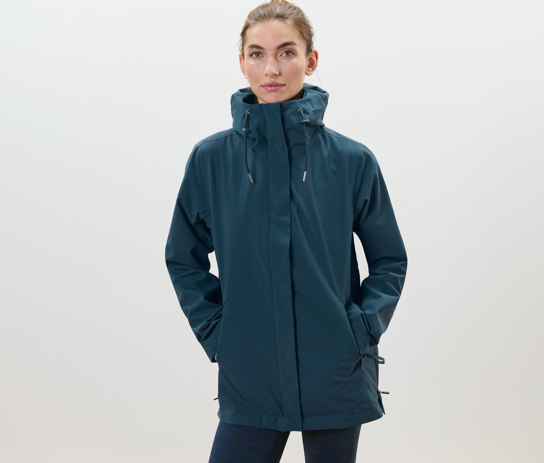 Nő visel egy sötétkék 3 az 1-ben túradzsekit.