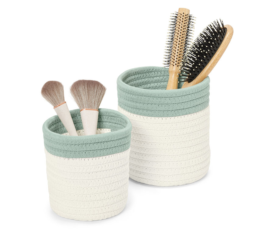 Két tárolókosár, az egyikben sminkecsetek, a másikban hajkefék.