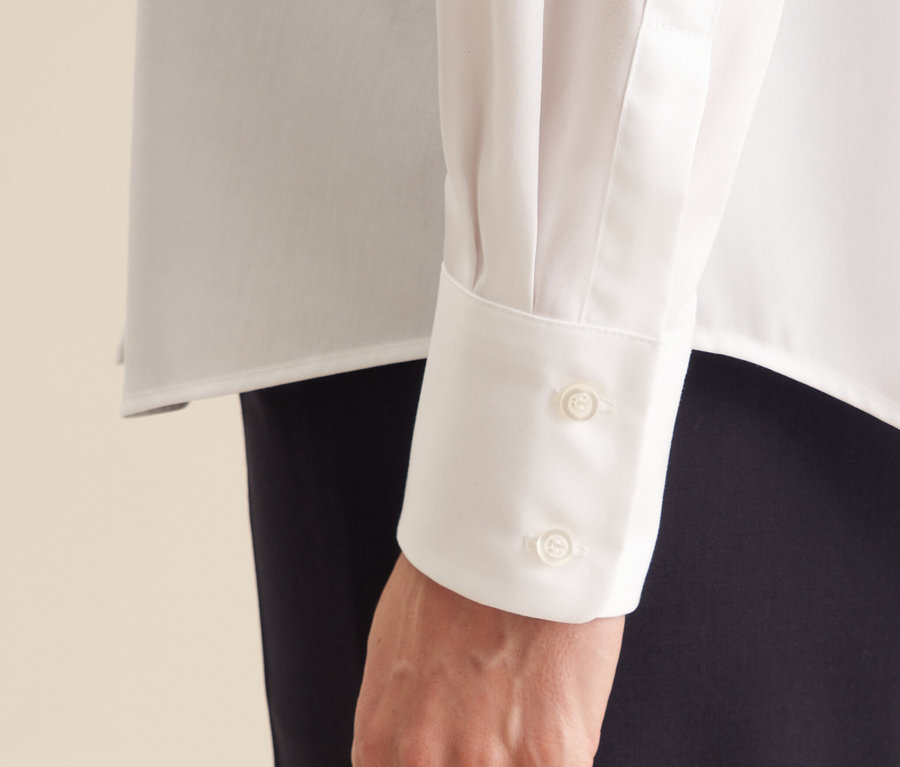 Egy kéz részlete a Seidensticker női vasalásmentes blúzban, két gombbal a mandzsettán.