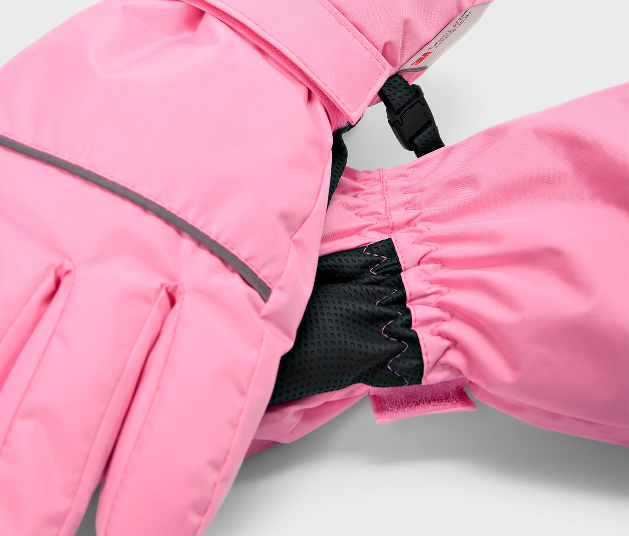 Rózsaszín gyermek síkesztyű részlete fekete belső mandzsettával.