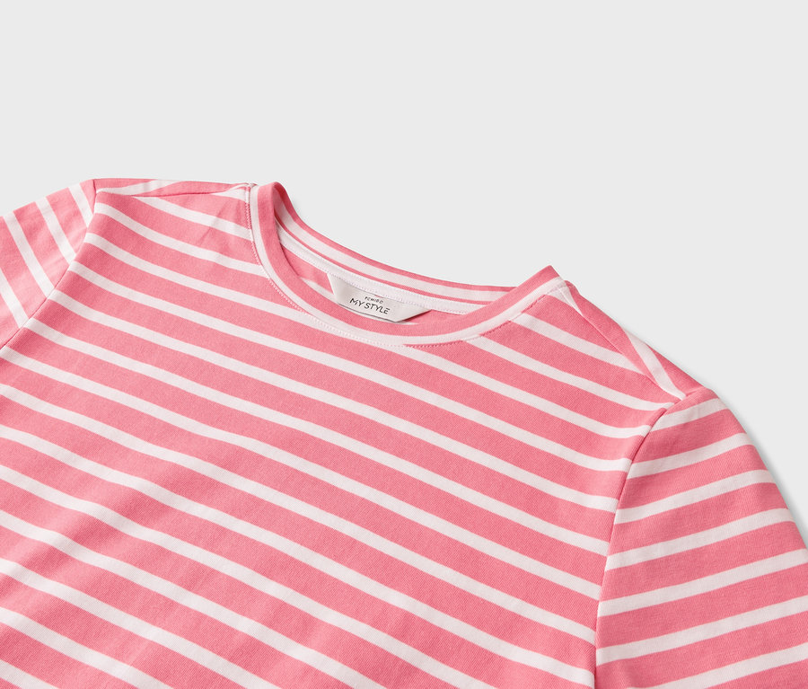 Egy rózsaszín-fehér, vízszintes csíkos póló közeli képe.