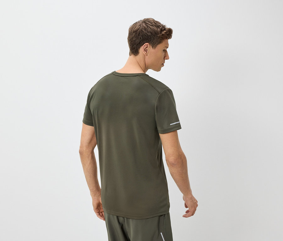 Hátulról látható férfi, zöld pólót és rövidnadrágot visel.