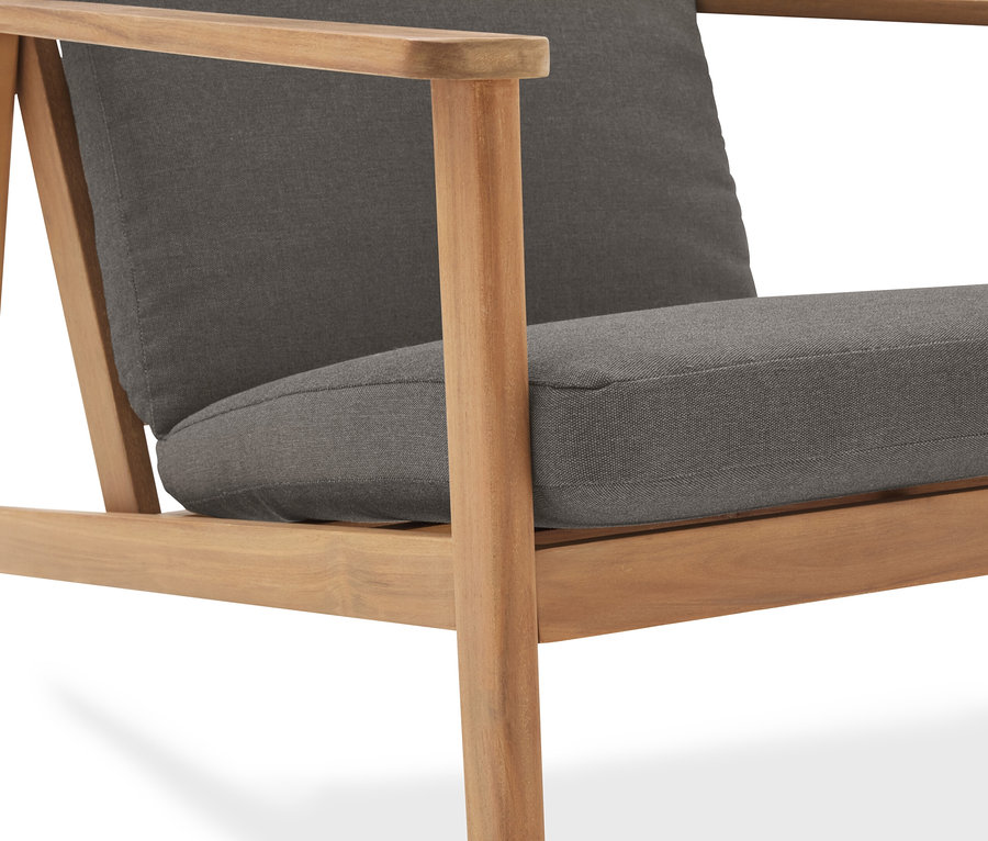 Egy fa vázas, szürke kárpitozású fotel részletfotója.