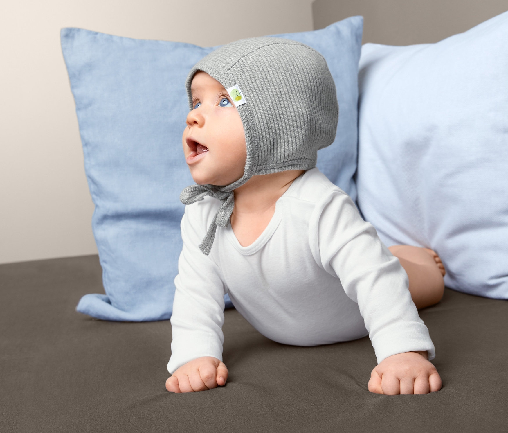 Baba a hasán fekszik, baba sapka van rajta.