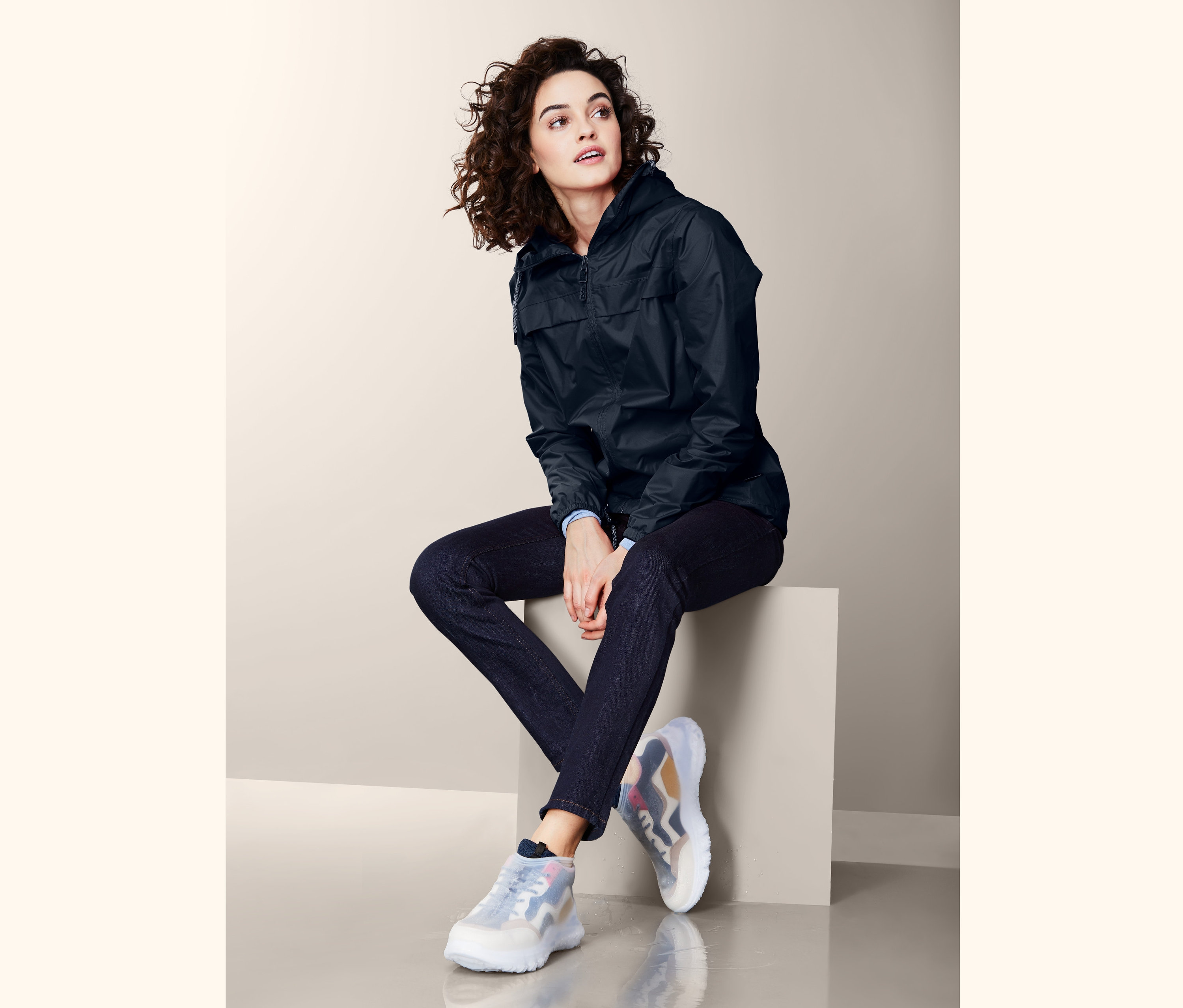 Nő ül egy tömbön, és Cipőre húzható esővédőt visel.