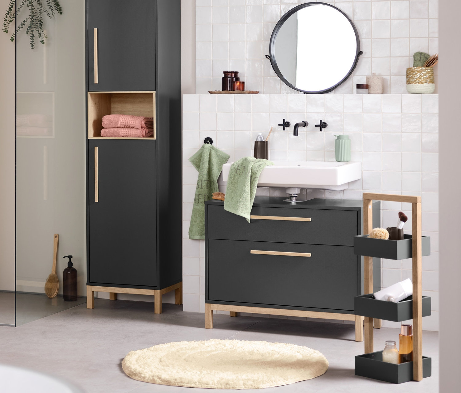 Fürdőszoba belső tér mosdóval, tükörrel és antracit Eklund fürdőszobai szekrényekkel. Előtérben egy fürdőkád.