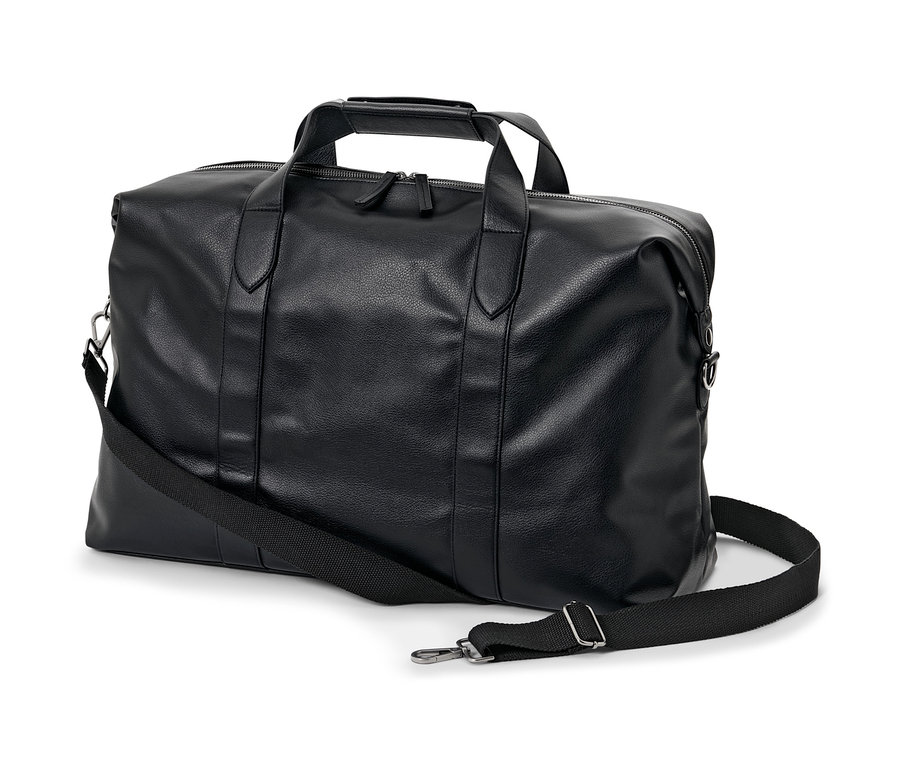 Egy fekete műbőr utazótáska vállpánttal fehér háttéren.
