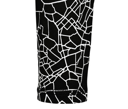 Egy fekete-ezüst színű, hosszú ujjú funkcionális felső részletének közeli képe, geometrikus mintával.