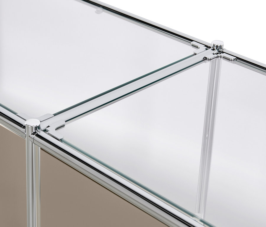 Közelkép a szürkésbarna »CN3« fém komód lenyíló ajtóiról és üvegpolcairól.