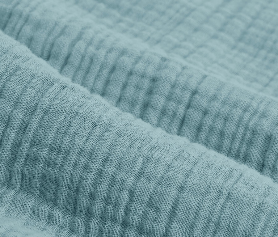 Különböző méretű kék muszlin ágynemű részlete.