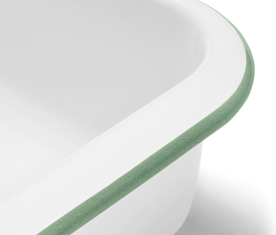 Egy fehér zománcozott sütőforma részlete zöld szegéllyel.