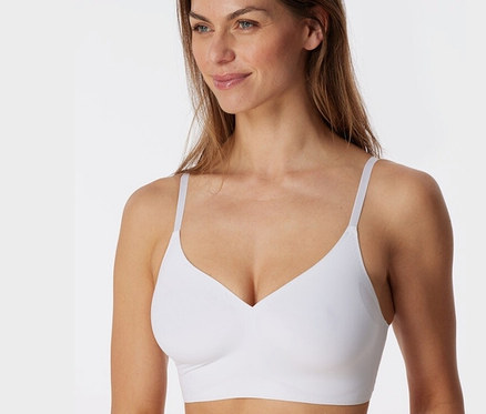 Nő visel egy fehér SCHIESSER láthatatlan betétes bustier melltartót.