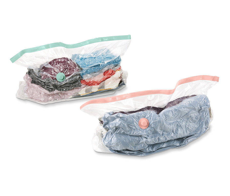 Két vákuumos tárolótasak, kocka alakú, ruhákkal töltve, fehér háttér előtt.