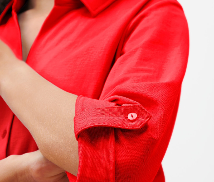 Egy nő részlete egy piros piké jersey blúzban.