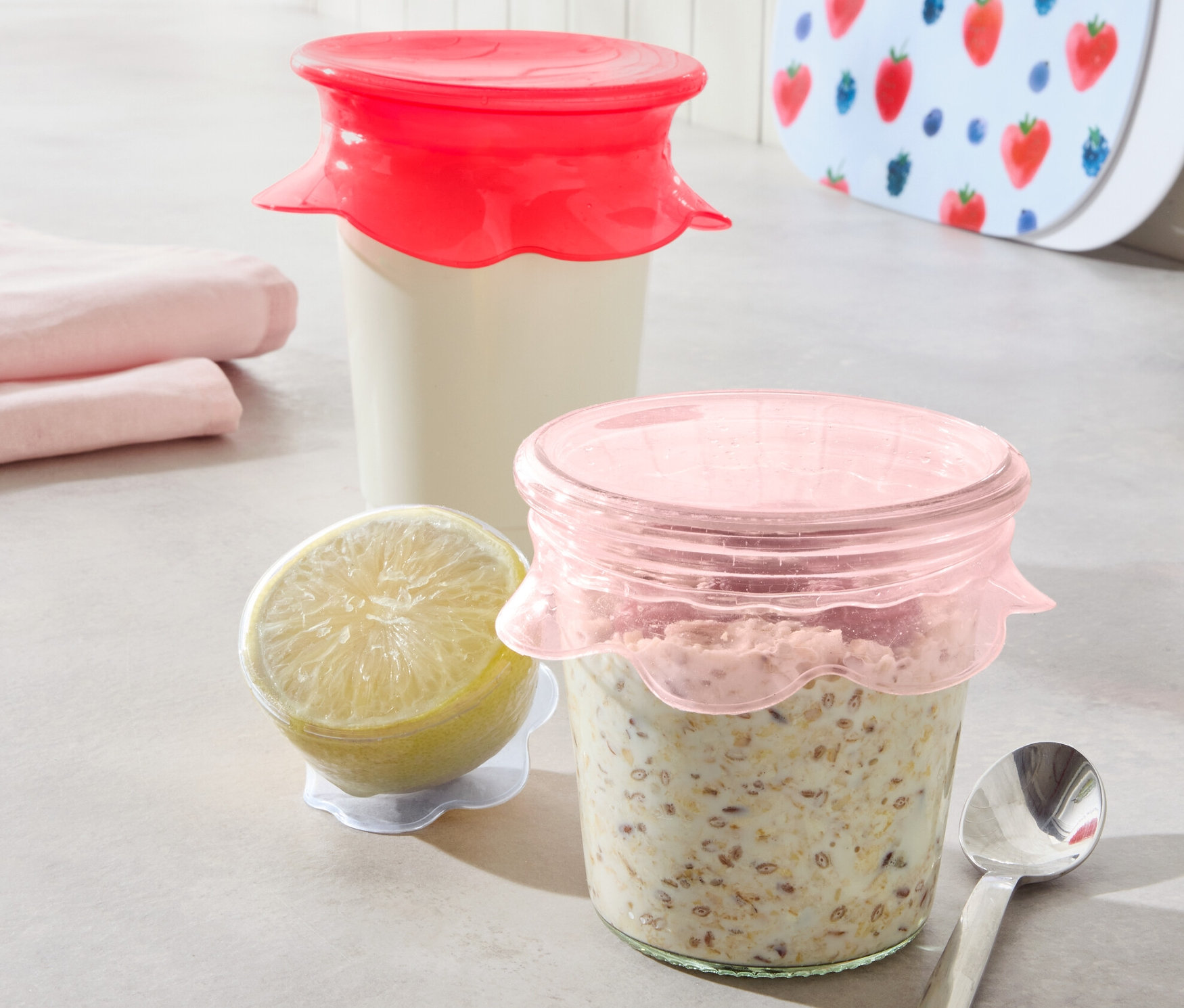 Két üveg tartalommal, 3 szilikon frissentartó fedéllel lefedve. Mellette egy citrom és egy kanál.