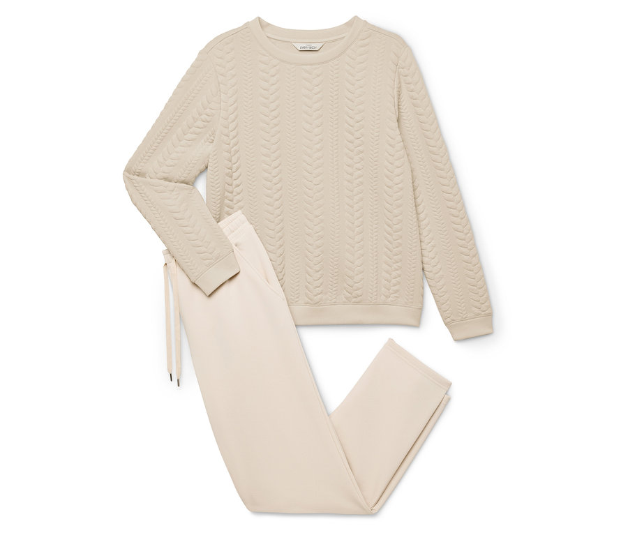 Bézs színű otthoni szett, mely egy kötött mintás pulóverből és egy húzózsinóros nadrágból áll.