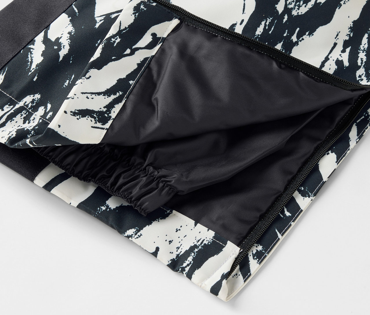 Egy fekete-fehér mintás nadrág részlete nyitott zsebbel.