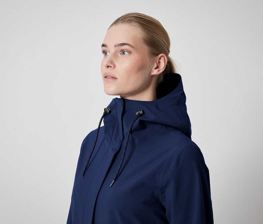 Egy nő sötétkék, kapucnis kabátot visel.