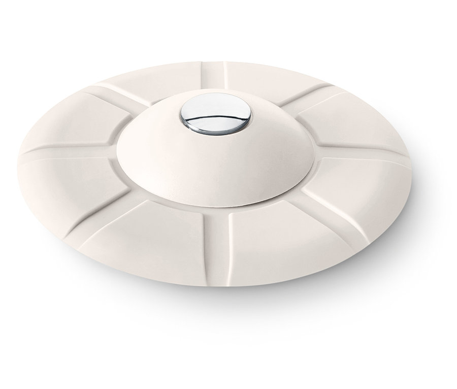 Krémszínű, kerek tárgy domború tetővel és ezüst gombbal a közepén.