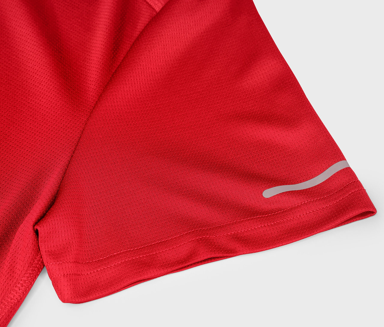 Egy piros, rövid ujjú sportpóló részlete, fényvisszaverő csíkkal.