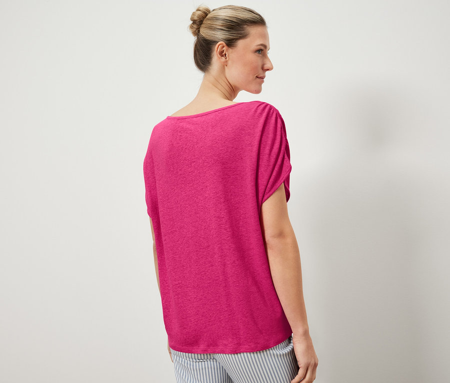 Nő visel egy pólót lentartalmú kevert anyagból és egy csíkos nadrágot.