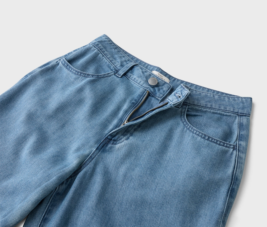 Egy világoskék farmernadrág közeli képe, nyitott cipzárral.