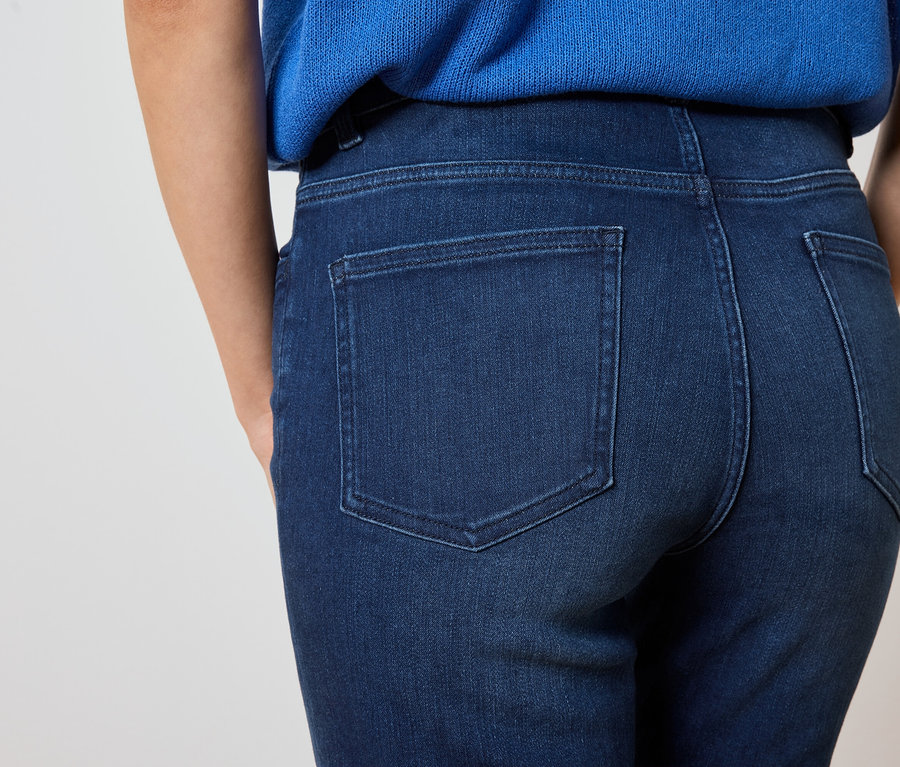 Közeli kép egy sötétkék farmernadrágot és kék felsőt viselő nő hátuljáról.