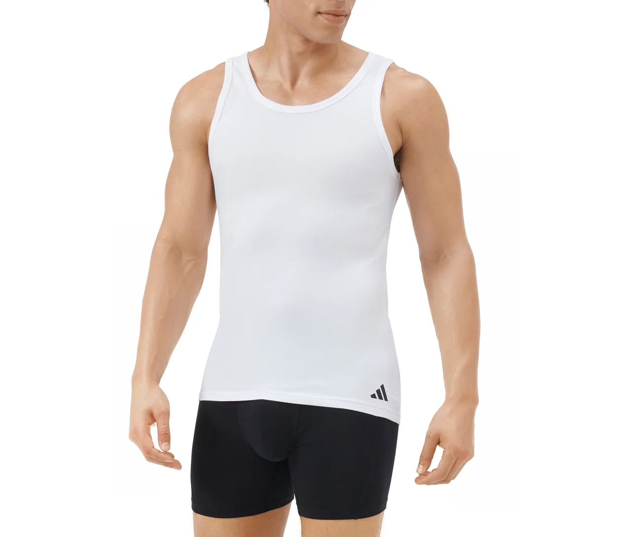 Férfi fehér atlétát visel fekete Adidas logóval a bal szegélyen, és fekete boxeralsót, fehér háttér előtt.