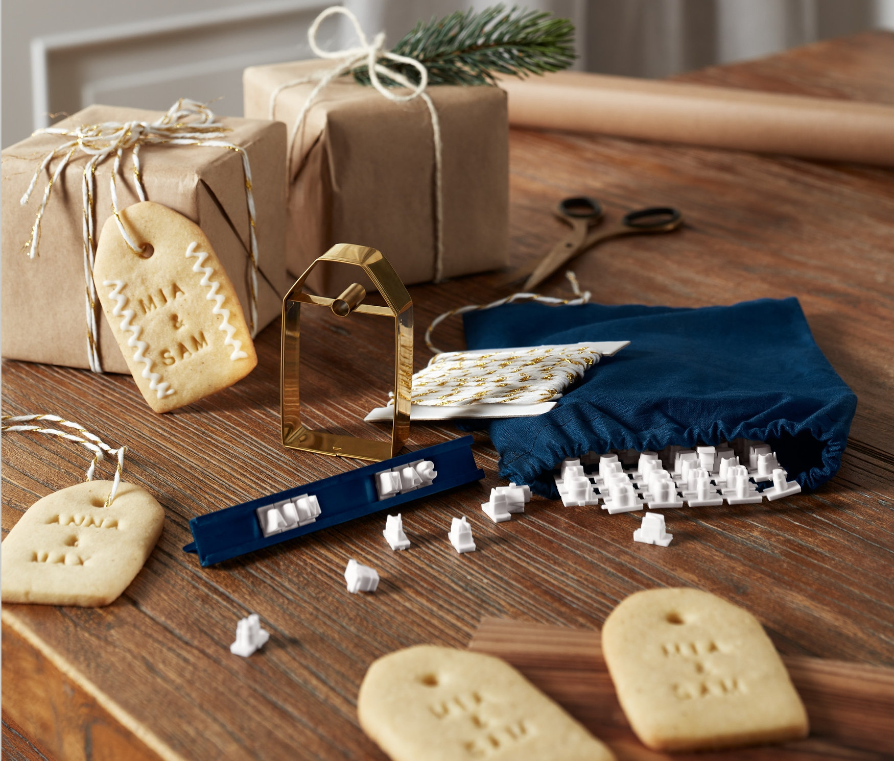 Keksznyomda készlet egy fa asztalon ajándékokkal és sült kekszekkel.