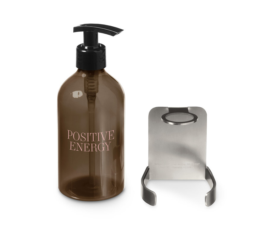 Barna üveg adagolóval és Positive Energy felirattal a Fali szappanadagoló tartó mellett.
