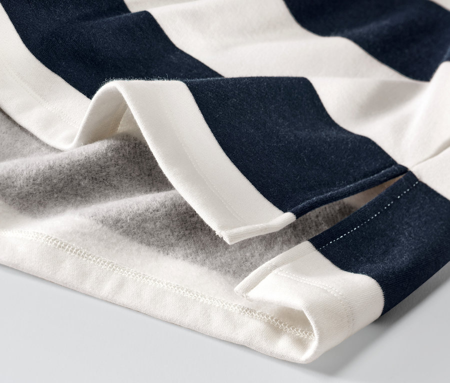 Egy csíkos kapucnis pulóver részlete.