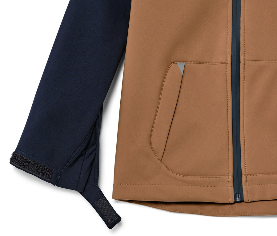 Részlet egy barna elejű és sötétkék ujjú gyerek softshell dzsekiből.