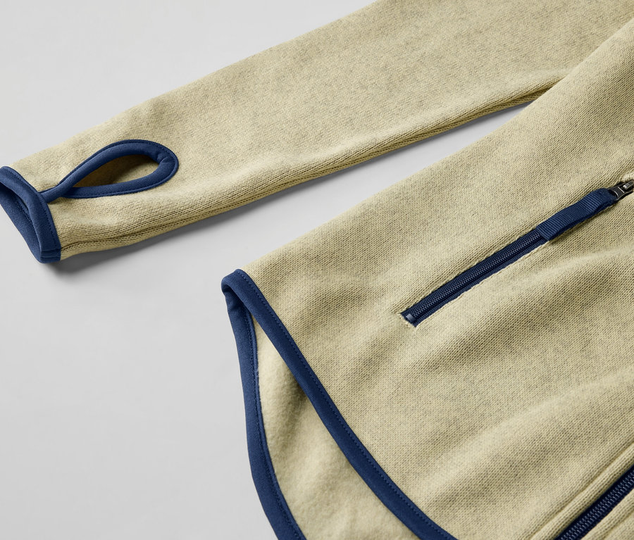 Egy sárga kötött polárfelső részlete kék díszítéssel és cipzárral.