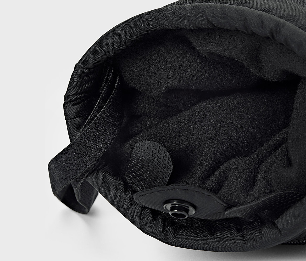 Egy fekete anyag részletfotója belső béléssel és húzózsinórral.