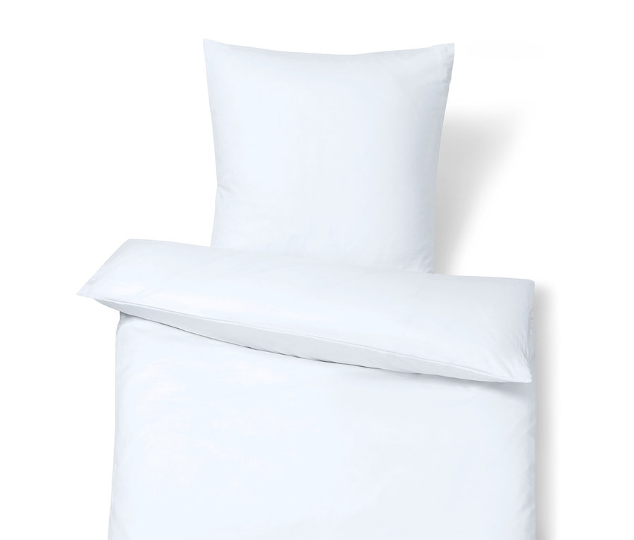 Egy fehér ágyneműgarnitúra részlete, felül egy párnával.
