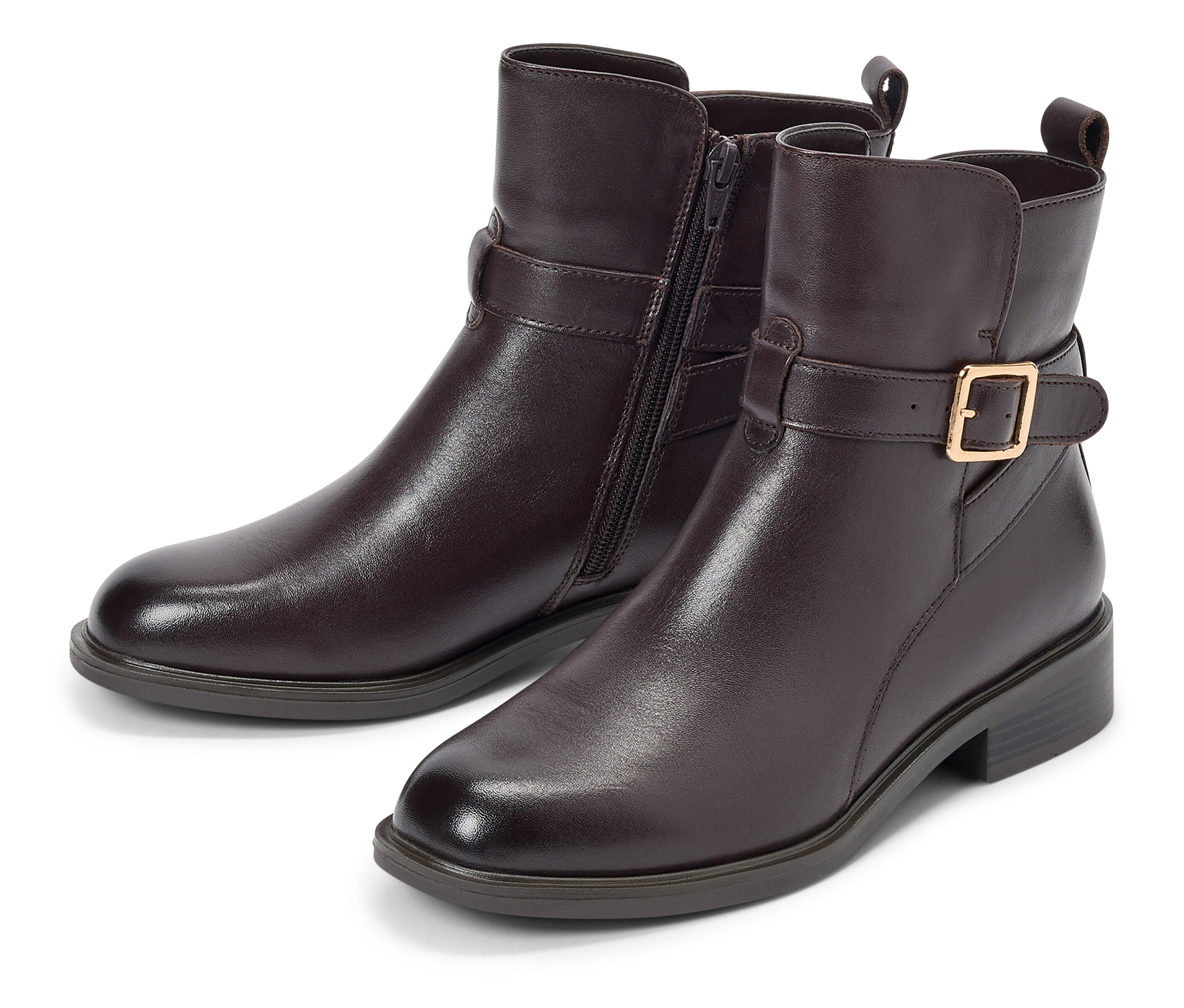 Két barna bokacsizma csattal és cipzárral fekszik egy fehér háttéren.