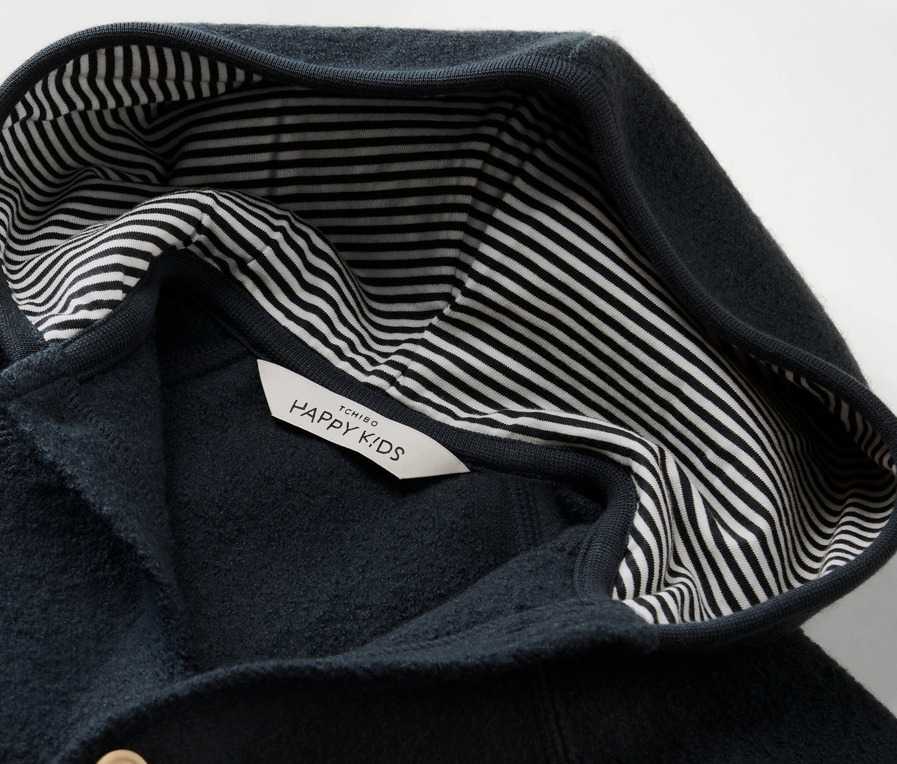 A kék Kisgyerek kezeslábas merinógyapjúval kapucnis, csíkos béléssel, részletgazdag képe.